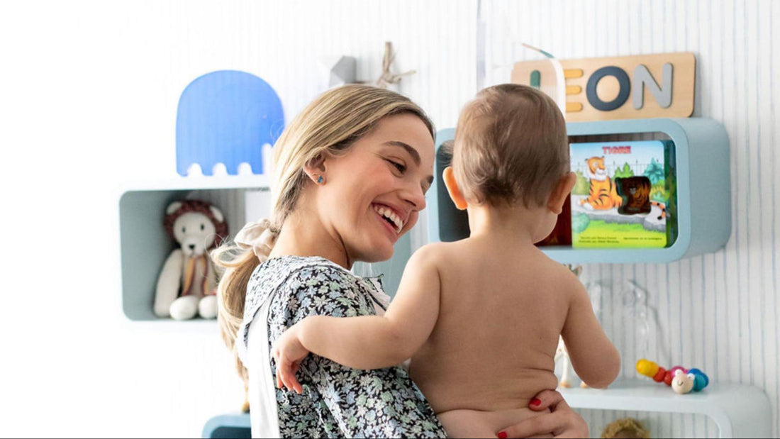 mom holding baby in nursery